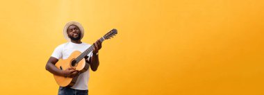 Kot pantolon ve beyaz kolsuz bluz giyen gitar, çalmak kas siyah adam. Sarı arka plan üzerinde izole