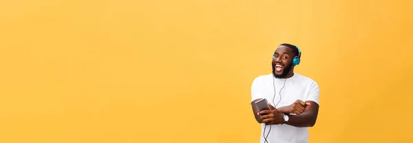 ヘッドフォンでアフリカ系アメリカ人は 聞くし 音楽とダンスします 黄色の背景に分離 — ストック写真