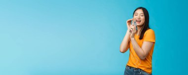 Neşeli, kaygısız, çekici Asyalı kadın. Gözlerini kapat. Zevk ve neşe, gülümse. Kulaklık tak, kulaklıkla müzik dinle..