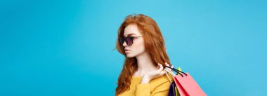 Alışveriş kavramı - portre genç güzel çekici Dişileştirilmiş kız kameraya alışveriş çantası ile seyir gülümseyen yakından. Mavi Pastel renkli. Kopya alanı