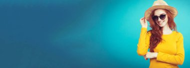 Seyahat kavramı - portre genç güzel çekici Dişileştirilmiş kız moda şapka ve sunglass gülümseyen yakından. Mavi Pastel renkli. Kopya alanı.