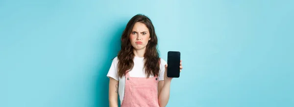 Разочарованная Девушка Хмурится Показывая Пустой Экран Смартфона Выглядит Недовольной Злой — стоковое фото
