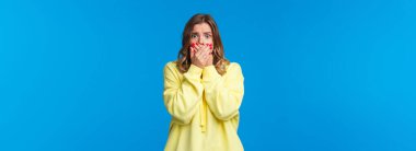 Dili tutulmuş ve endişeli genç bir kadın kötü bir kaza görüyor, filmdeki korkunç sahneyi görüyor, bağırmamak için elleriyle ağzını kapatıyor, korkmuş gözlerle bakıyor..