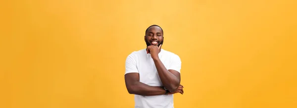 腕を組んで分離黄色背景に笑みを浮かべてモダンな若い黒人男性の肖像画 — ストック写真