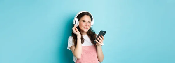 Menina Morena Elegante Fones Ouvido Segurando Smartphone Ouvindo Música Escolhendo — Fotografia de Stock