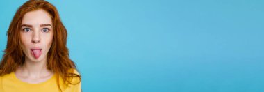 Komik surat kameraya bakarak mutlu Kızıl kızıl saçlı kızla headshot portresi. Pastel mavi arka plan. Kopya alanı.