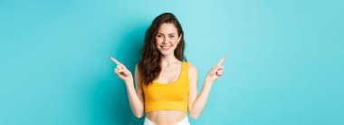 Sıranı seç. Tepede mükemmel bir vücudu olan, gülümseyen, iki tarafı gösteren, mavi arka planda duran güzel bir kadın..