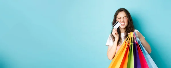 Χαρούμενη Νεαρή Γυναίκα Γελάει Δείχνει Τσάντες Για Ψώνια Και Πλαστική — Φωτογραφία Αρχείου