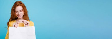 Alışveriş kavramı - portre genç güzel çekici Dişileştirilmiş kız kameraya Beyaz alışveriş çantası ile seyir gülümseyen yakından. Mavi Pastel renkli. Kopya alanı.
