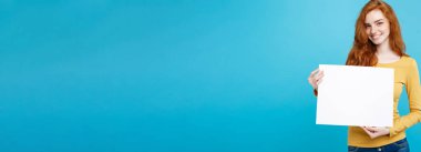 İş kavramı-portre genç güzel çekici Kızıl kızıl saçlı kız boş işaret gösteren gülümseyen yakın. Mavi Pastel renkli. Kopya alanı