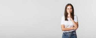 Şımarık, çekici esmer kız göz kırpıyor, kameraya şşşş yapıyor..