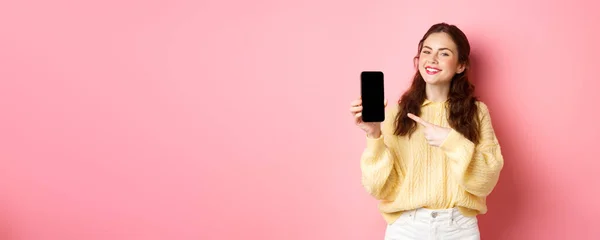 Retrato Atraente Jovem Mulher Demonstra Promo Telefone Apontando Dedo Para — Fotografia de Stock