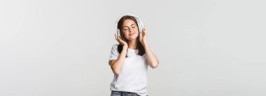Rüya gibi güzel kız kablosuz kulaklıkla müzik dinlemekten zevk alıyor, mutlu gülümsüyor..