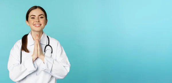 Sonriente Joven Doctora Esperanzada Cogida Mano Mendicidad Gracias Pose Pie — Foto de Stock