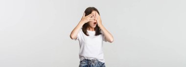 Tuhaf, güzel bir kız gülümsüyor ve şaşkınlığı bekliyor gözleri kapalı, parmaklarından bakıyor..