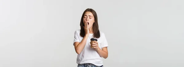 피곤하고 매력적 아가씨가 테이크 배경을 마시면서 하품하는 — 스톡 사진
