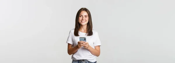 Attraktives Lächelndes Brünettes Mädchen Das Sms Schreibt Mobiltelefone Benutzt Und — Stockfoto