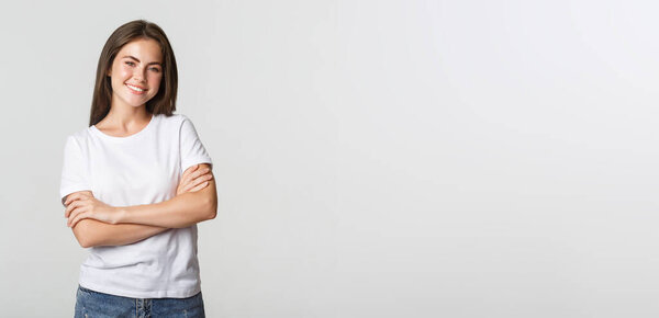 Portrait of confident attractive woman, cross arms chest and smiling pleased.