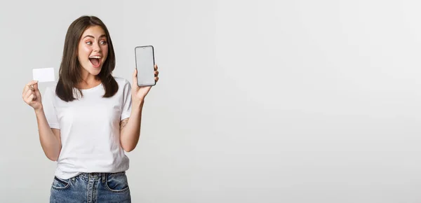 Aufgeregt Und Überrascht Süßes Mädchen Zeigt Kreditkarte Und Handy Banking — Stockfoto