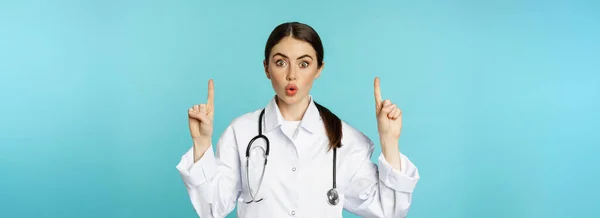 Retrato Jovem Médico Surpreso Mulher Assistente Médica Apontando Dedos Para — Fotografia de Stock