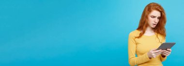 Portre genç güzel çekici ihale zencefil Dişileştirilmiş kız dijital masada bir şey yeme içme ile gülümseyen mutlu kapatın. Mavi Pastel renkli. Kopya alanı.