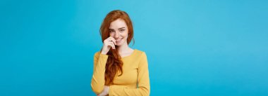 Yaşam tarzı kavramı - portre genç güzel çekici Kızıl kızıl saçlı kız saçını utangaçlık ile oynamaktan yakından. Mavi Pastel renkli. Kopya alanı