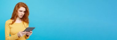 Portre genç güzel çekici ihale zencefil Dişileştirilmiş kız dijital masada bir şey yeme içme ile gülümseyen mutlu kapatın. Mavi Pastel renkli. Kopya alanı.