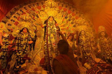 Kolkata, Batı Bengal, Hindistan - 7 Ekim 2019: Tanrıça Durga 'ya, kutsal dumanla sondhipujo aarti sırasında kutsal pradip ile Hindu rahip tarafından tapılıyor..