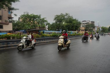 Kolkata, Batı Bengal, Hindistan - 4 Ağustos 2020: Muson yağmurlarında Kolkata trafiğinin görüntüsü... Scooter sürücüleri geçiyor. Westbengal 'in başkenti olan Kolkata, eyaletin maksimum trafiğine sahip..