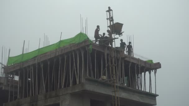 2021年9月12日インド 西ベンガル州ハウラー 高層ビルの屋根の上の鋳造 セメントは壁の横に一時的なエレベーターで運ばれています インド人労働者 — ストック動画