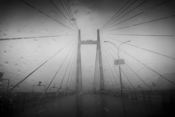 Vidyasagar Setu (Bridge) over river Ganges, known as 2nd Hooghly Bridge in Kolkata,West Bengal, India. Abstract image shot aginst glass with raindrops all over it, Black and white.