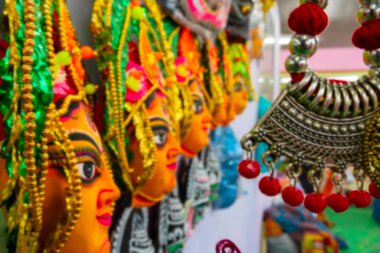 Hindu Tanrıça Durga 'nın renkli chhou maskelerinin ve el yapımı kolyelerin bulanık görüntüsü, el sanatları fuarında sergileniyor, Kolkata, Batı Bengal, Hindistan.