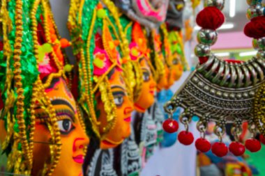Hindu Tanrıça Durga 'nın renkli chhou maskelerinin ve el yapımı kolyelerin bulanık görüntüsü, el sanatları fuarında sergileniyor, Kolkata, Batı Bengal, Hindistan.