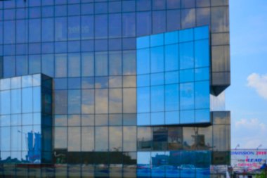 Kolkata 'nın bulanık görüntüsü, Batı Bengal, Hindistan. Binaların modern mimarisi, cam dış görünüşü mavi gökyüzünü, beyaz bulutları ve binaları yansıtıyor..