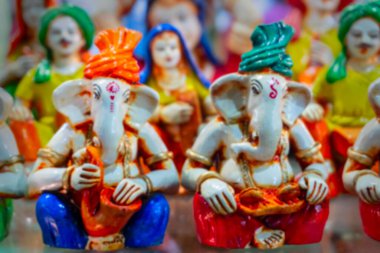 Kolkata 'nın bulanık görüntüsü, Batı Bengal, Hindistan. Renkli Lord Ganesha Terracotta ve Krishnanagar, Nadia 'da el sanatları fuarında satılan geleneksel Hint elbiseleri giymiş diğer bebekler..
