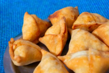 Ev yapımı Samosa, samsa ya da smosa 'nın bulanık görüntüsü. Geleneksel Hint özel vejetaryen sokak yemekleri. Iftaari yemeği, Seçmeli odak.