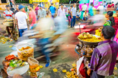 Howrah 'ın bulanık görüntüsü, Batı Bengal, Hindistan. Hindu Bengali düşkünleri yol kenarındaki Hint Bengali yemeği chotpoti ve velpuri 'nin tadını çıkarıyorlar. Hareketli insanların hareket bulanıklığını göstermek için yavaş deklanşör kullan.