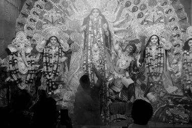 Kolkata, Batı Bengal, Hindistan - 7 Ekim 2019: Hindu rahip tarafından kutsal dumanla sondhipujo aarti sırasında kutsal panchapradip ile tanrıça Durga 'ya tapılıyor. Siyah ve beyaz.