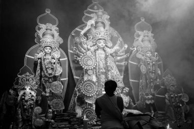 Howrah, Batı Bengal, Hindistan - 5 Ekim 2019: Hindu rahip Sanskritçe shloka söyleyerek tanrıça Durga 'ya tapıyor. Kutsal duman Tanrıça 'yı örtüyor. Hinduizm 'in en büyük festivali. B&W.