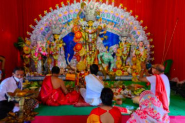 Tanrıça Durga 'nın bulanık görüntüsü, sondhipujo aarti sırasında Hindu rahipler tarafından tapılıyor. Covid 19 salgını sırasında Durga puja.