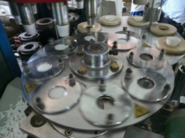 Kağıt bardakların bulanık görüntüsü kağıttan yapılıyor, kağıt bardak üretim makineleri kullanılarak, çalışan bir bardak imalatı veya üretim ünitesi görünümünde.