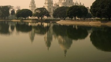 Kolkata, Hindistan 'da bulunan Kolkata şehrinin en ünlü anıtlarından biri olan Victoria Memorial' ın Timelapse video klibidir. Ön plandaki göl suyunun yansıması. Eğik atış.