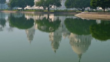 Kolkata 'daki büyük mermer bina Victoria Memorial' ın 4K stok videosu, Kolkata 'nın ünlü anıtı, Batı Bengal, Hindistan. Binanın tepesinin ön plandaki göl suyunun yansıması..