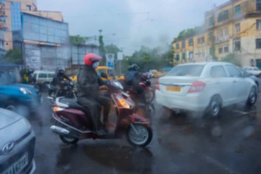 Kolkata 'nın bulanık görüntüsü, Batı Bengal, Hindistan. Görüntü, ıslak camlara düşen yağmur damlalarından, trafiğin soyut bulanıklıklarından, Kolkata 'nın (eski adıyla Kalküta) muson stok görüntülerinden alınmıştır. ,