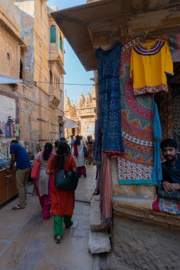 Jaisalmer, Rajasthan, Hindistan - 13 Ekim 2019: Jaisalmer Kalesi 'nin içindeki pazar yerinde sabah vakti renkli giysiler satılıyor. Thar Çölündeki UNESCO dünya mirası sahası.