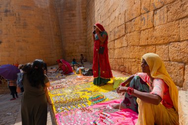 Jaisalmer, Rajasthan, Hindistan - 13 Ekim 2019: Rajasthani kadınları Jaisalmer Kalesi 'nin içindeki pazar yerinde mücevher satıyorlar. Popüler turizm pazarı.
