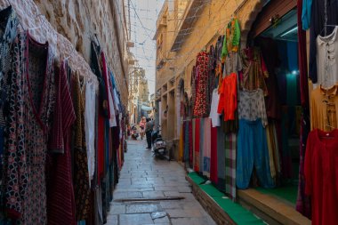 Jaisalmer, Rajasthan, Hindistan - 13 Ekim 2019: Jaisalmer Kalesi 'nin içindeki pazar yerinde sabah vakti renkli giysiler satılıyor. Thar Çölündeki UNESCO dünya mirası sahası.
