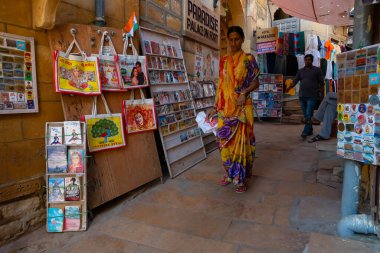 Jaisalmer, Rajasthan, Hindistan - 13 Ekim 2019: Renkli çantalar ve el çantaları sabah saatlerinde Jaisalmer Kalesi 'nin içindeki pazar yerinde satılmak üzere turistlere sunuluyor. UNESCO dünya mirası sahası.