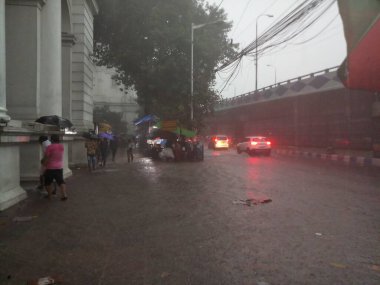 Kolkata, Batı Bengal, Hindistan - 16 Ağustos 2019: Hint müzesi yakınlarındaki su dolu patikada yürüyen yayalar. Kolkata 'da muson yağmurları,