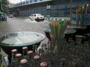 Kolkata, Batı Bengal, Hindistan - 16 Ağustos 2019: Arka planda muson yağmurları altında bir yol kenarı dükkânı ıslanıyor. Sarı taksi bekliyor. Kolkata 'nın yağışlı sezonu,